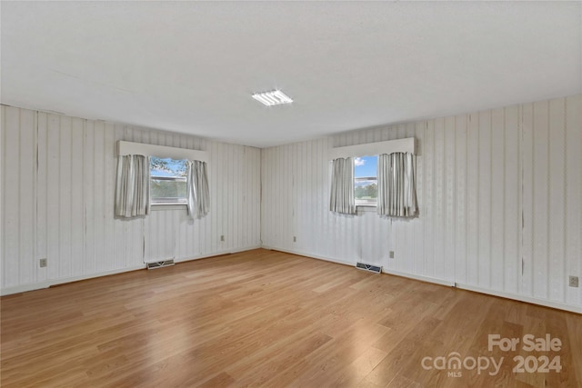 unfurnished room with light wood-type flooring and a healthy amount of sunlight