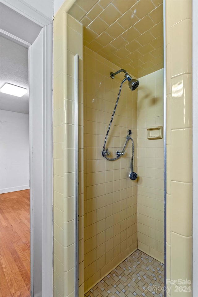 bathroom with hardwood / wood-style floors and a tile shower