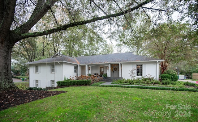 single story home with a front yard and covered porch