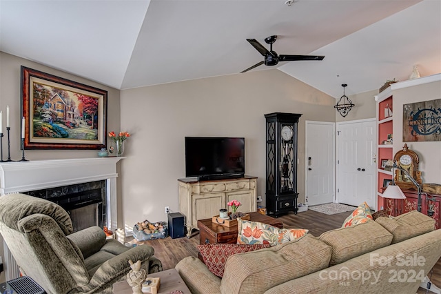 living room featuring a premium fireplace, hardwood / wood-style flooring, ceiling fan, and vaulted ceiling