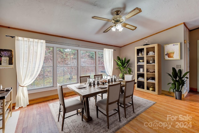 dining space featuring ornamental molding, a textured ceiling, vaulted ceiling, ceiling fan, and light hardwood / wood-style floors