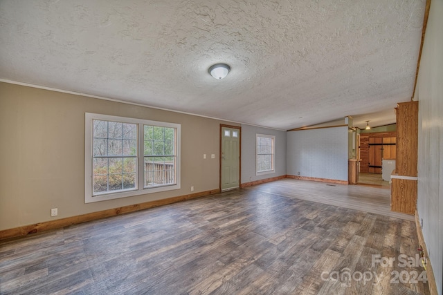 unfurnished living room featuring hardwood / wood-style flooring, lofted ceiling, a textured ceiling, and ornamental molding