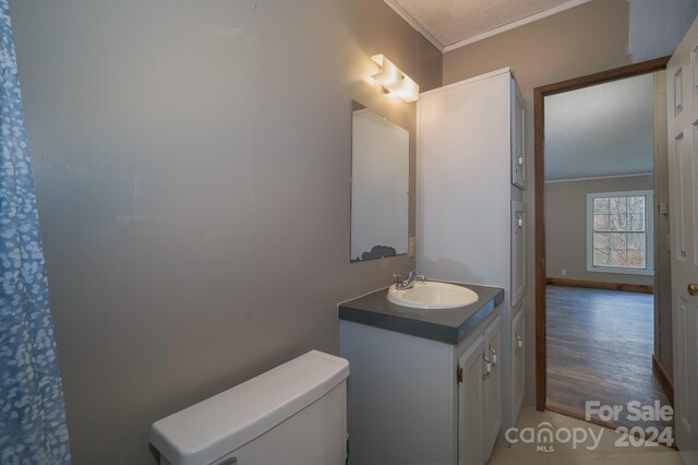 bathroom featuring hardwood / wood-style floors, vanity, toilet, and crown molding