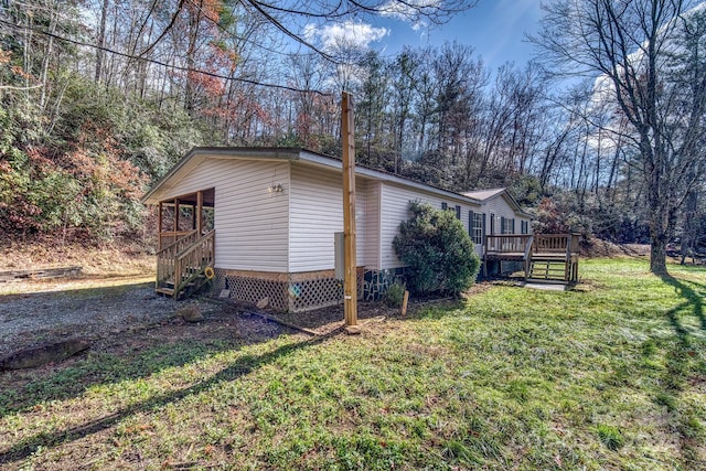 view of side of property with a lawn and a wooden deck