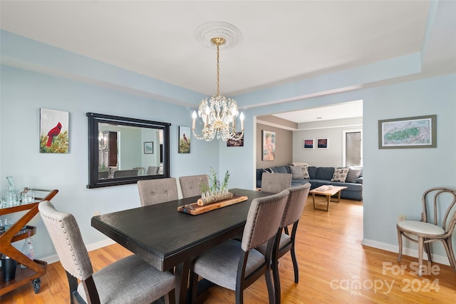 dining space featuring light wood-type flooring and a chandelier