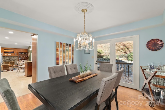 dining space featuring light hardwood / wood-style floors and an inviting chandelier