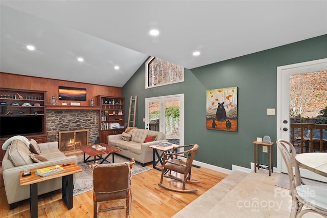 living room with a fireplace, high vaulted ceiling, and wood-type flooring