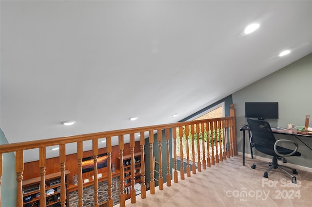 home office with light colored carpet and vaulted ceiling