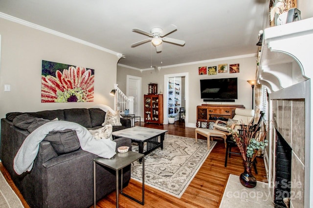 living room featuring hardwood / wood-style floors, ceiling fan, and crown molding