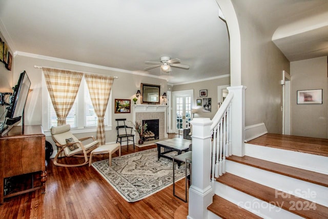 living room with wood-type flooring, ceiling fan, and crown molding