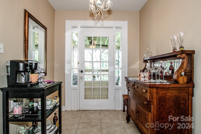 entryway featuring light tile patterned floors and a notable chandelier