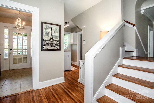 stairway with an inviting chandelier and hardwood / wood-style flooring