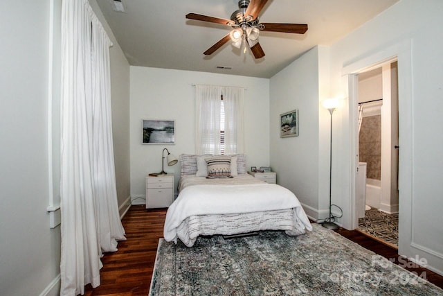 bedroom featuring ensuite bath, dark wood-type flooring, and ceiling fan