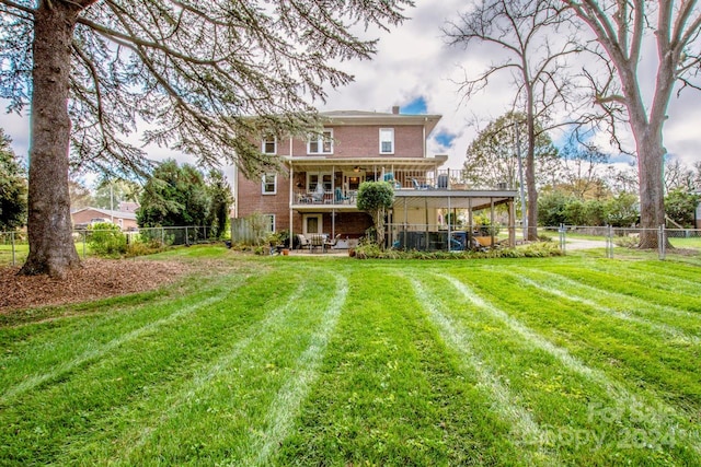 back of house featuring a lawn and a patio area