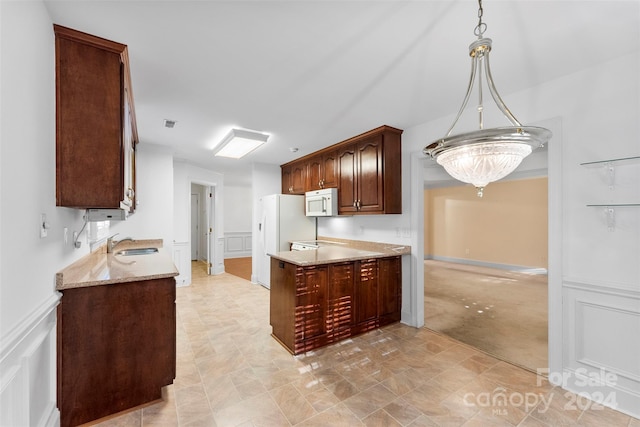 kitchen with light carpet, sink, light stone counters, hanging light fixtures, and white appliances