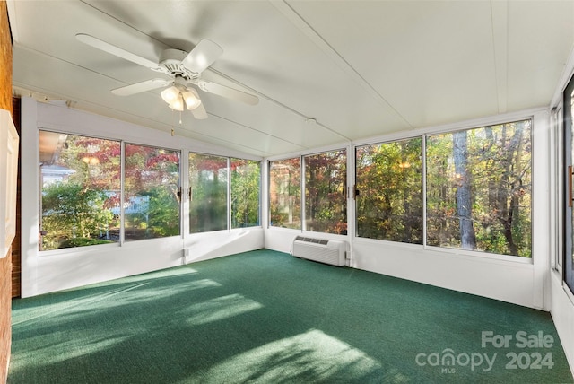 unfurnished sunroom featuring ceiling fan, a healthy amount of sunlight, vaulted ceiling, and a wall mounted air conditioner