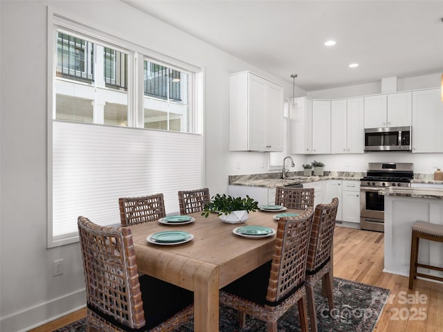 dining space with baseboards, light wood-style floors, and recessed lighting