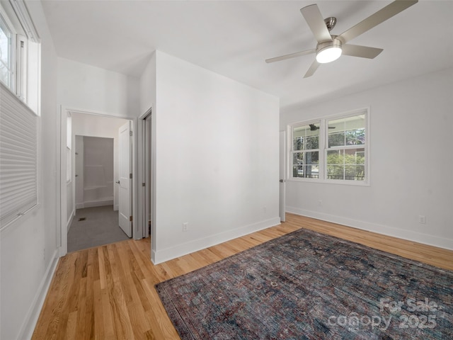empty room with baseboards, light wood-style floors, and ceiling fan