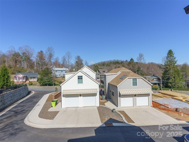view of front of property featuring a residential view, driveway, and a garage