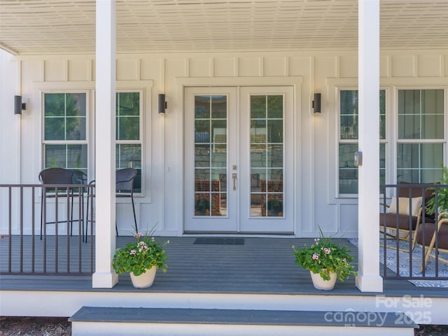 view of exterior entry with board and batten siding and french doors