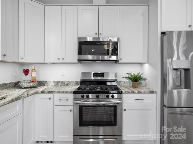 kitchen featuring white cabinetry, appliances with stainless steel finishes, and light stone counters