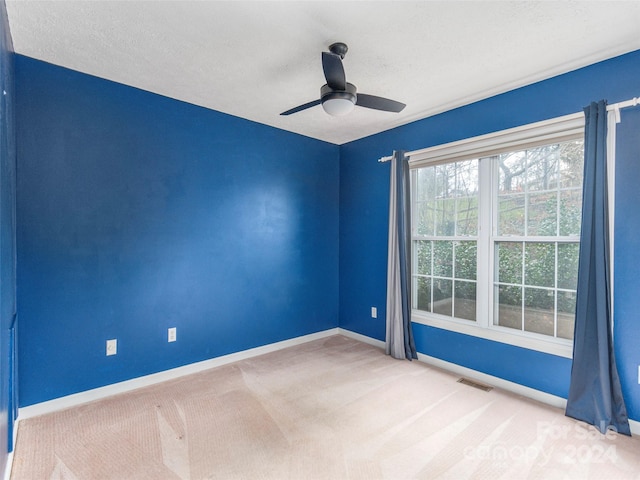 unfurnished room featuring ceiling fan, carpet, and a textured ceiling