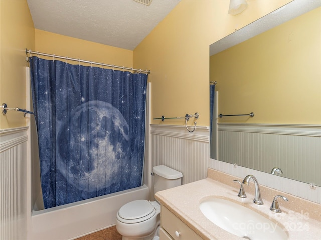 full bathroom with shower / bathtub combination with curtain, tile patterned floors, vanity, toilet, and a textured ceiling