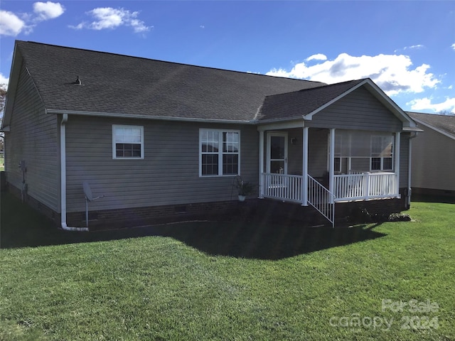 back of property with a lawn and covered porch