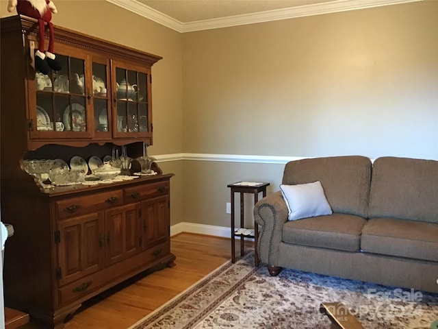 bar featuring light hardwood / wood-style flooring, dark brown cabinets, and ornamental molding