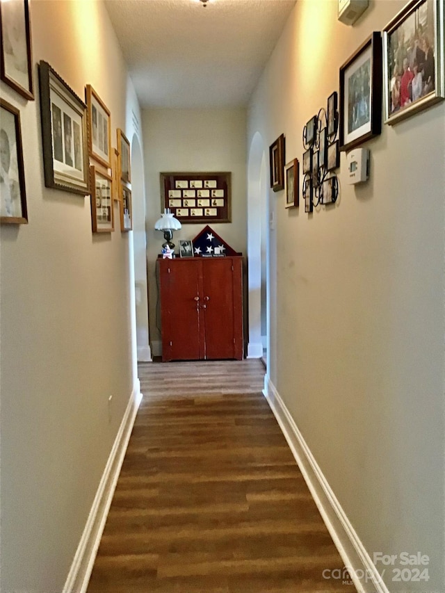 corridor with dark hardwood / wood-style flooring