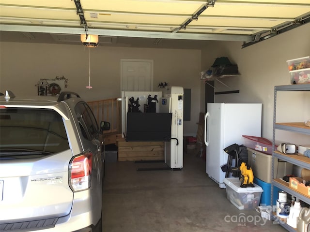 garage with white fridge and a garage door opener