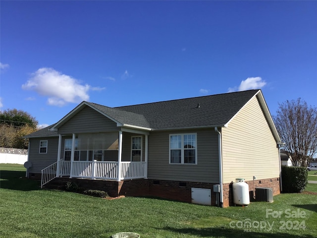 back of property featuring central AC and a lawn