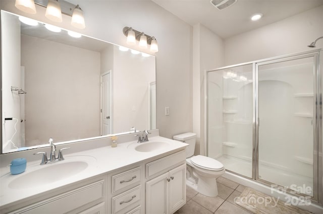 bathroom with tile patterned floors, toilet, a shower with door, and vanity