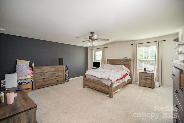 bedroom featuring multiple windows, ceiling fan, light colored carpet, and a fireplace