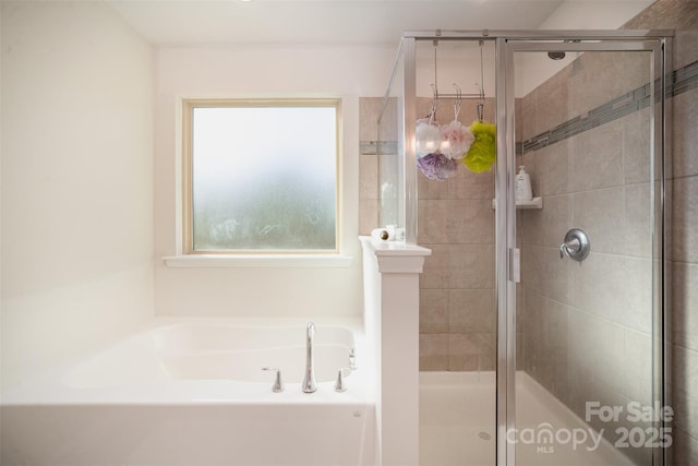 bathroom featuring plenty of natural light and separate shower and tub