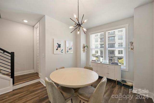 dining area with dark hardwood / wood-style flooring and an inviting chandelier