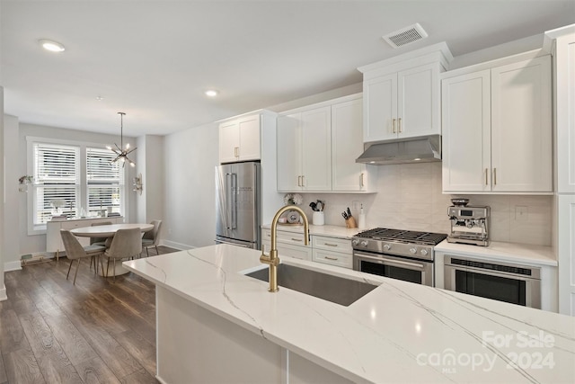 kitchen featuring high end appliances, white cabinets, hanging light fixtures, sink, and dark hardwood / wood-style floors