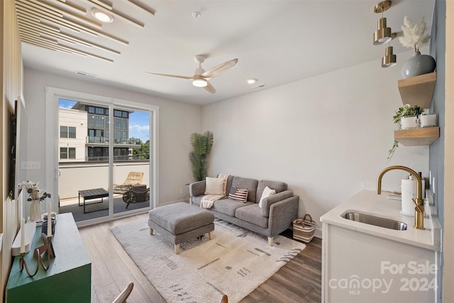 living room with sink, hardwood / wood-style flooring, and ceiling fan