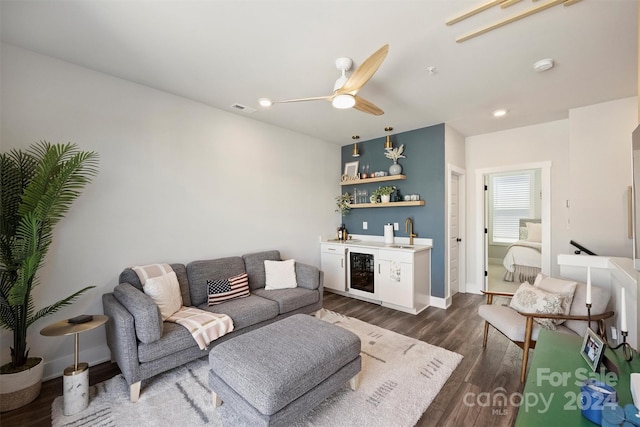 living room featuring dark wood-type flooring, ceiling fan, indoor bar, and wine cooler