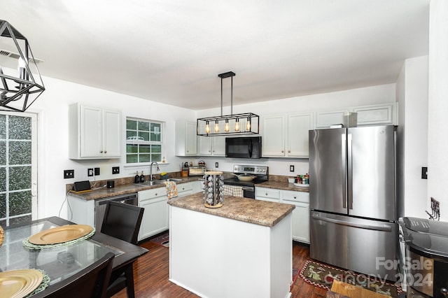 kitchen with white cabinets, black appliances, decorative light fixtures, and a center island