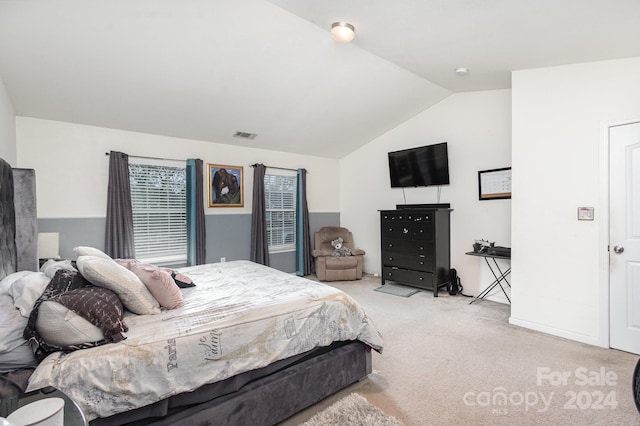 carpeted bedroom with lofted ceiling