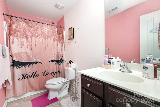 bathroom with toilet, vanity, and tile patterned floors