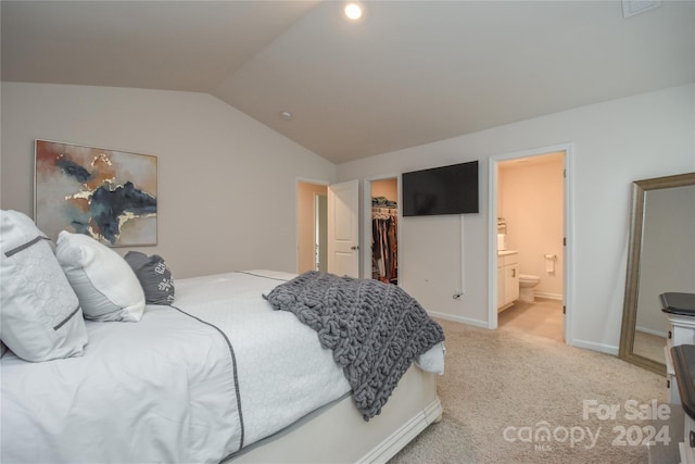 bedroom featuring ensuite bathroom, light colored carpet, vaulted ceiling, a spacious closet, and a closet