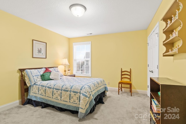 bedroom with a closet, carpet, and a textured ceiling