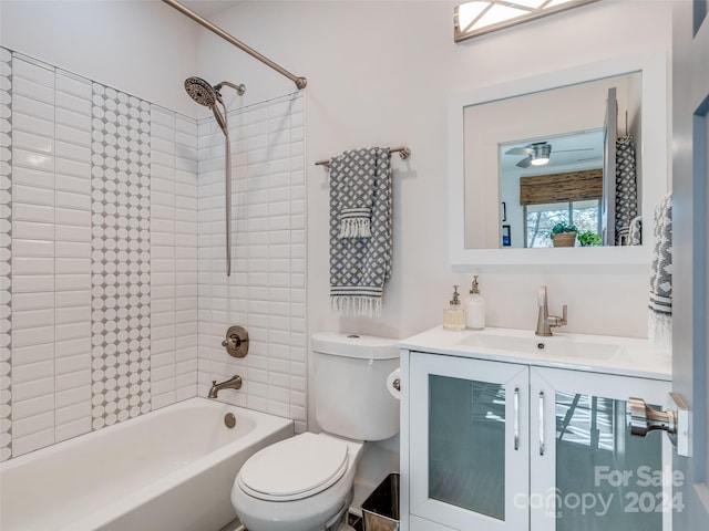 full bathroom featuring tiled shower / bath combo, toilet, and vanity