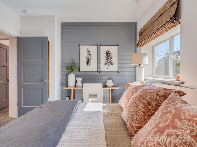 bedroom featuring wood walls and hardwood / wood-style floors