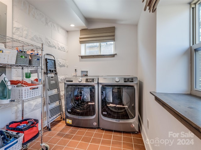 laundry area featuring separate washer and dryer, light tile patterned floors, and a healthy amount of sunlight