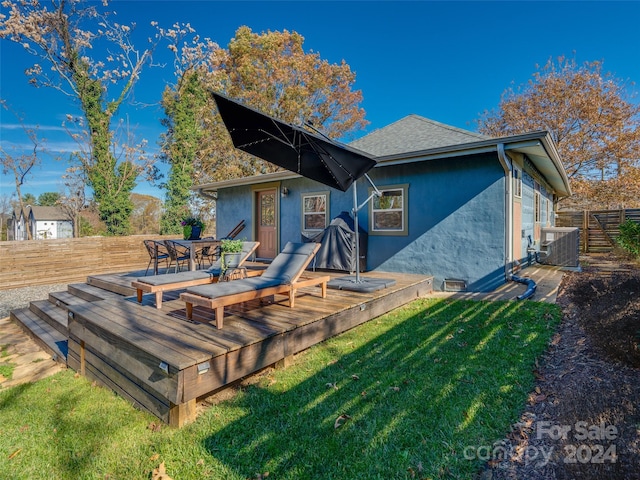 back of property with central AC unit, a yard, and a wooden deck