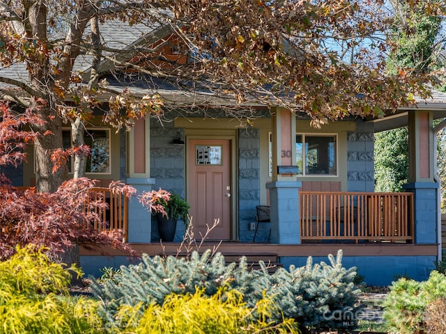 view of exterior entry featuring covered porch