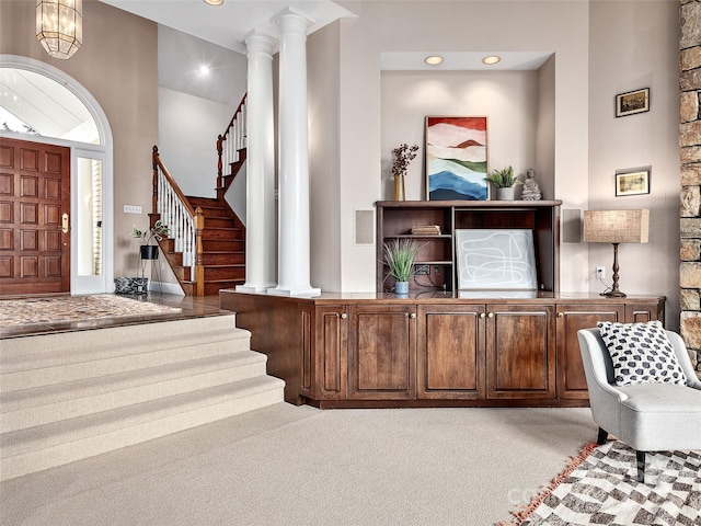 foyer featuring stairway, an inviting chandelier, carpet, ornate columns, and recessed lighting